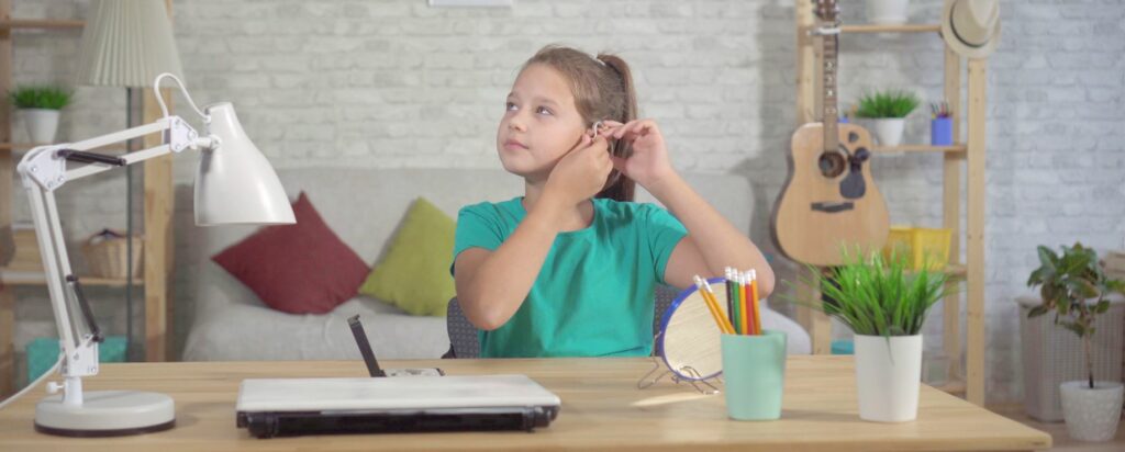 Young Person Putting Hearing Aid On