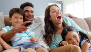 Family Watching TV Loudly Enjoying Themselves